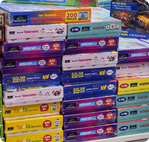 Een stapel dozen met kinderpuzzels met verschillende thema’s in de etalage van de winkel