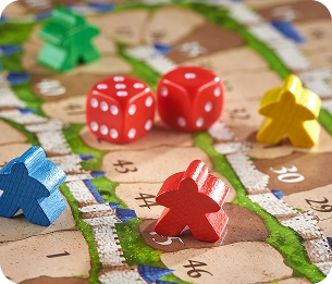 Gekleurde speelstukken en dobbelstenen op het bord van een bordspel